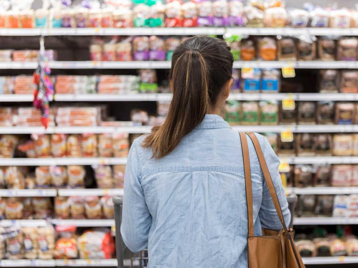 Kvinde ser på kornprodukter i supermarked