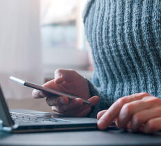 En person bruger både sin computer og mobil og skal være sikker online