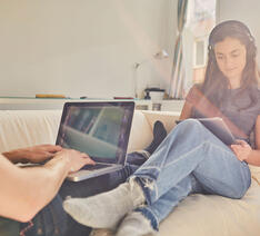 To personer sidder med deres computer og tablet