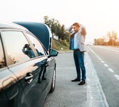 Mand i på bilferie i udlandet med en bil, der er brudt sammen