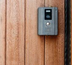 Ringeklokke med kamera på trædør.