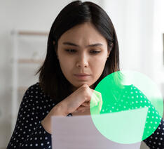 Kvinde kigger på papir med oversigt over gebyrer på investeringer