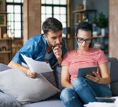Ungt par kigger på lånetilbud fra bank og realkreditinstitut