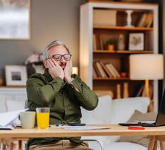 Mand ved skrivebord ser frustreret ud